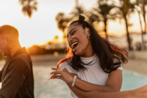 Young woman dancing with friends outdoors