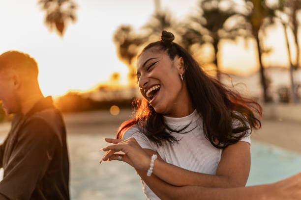 Young woman dancing with friends outdoors